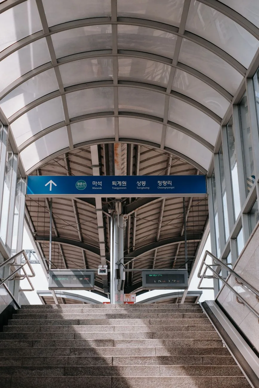 View of a modern glass-roofed train station entrance in Chuncheon-si, South Korea.