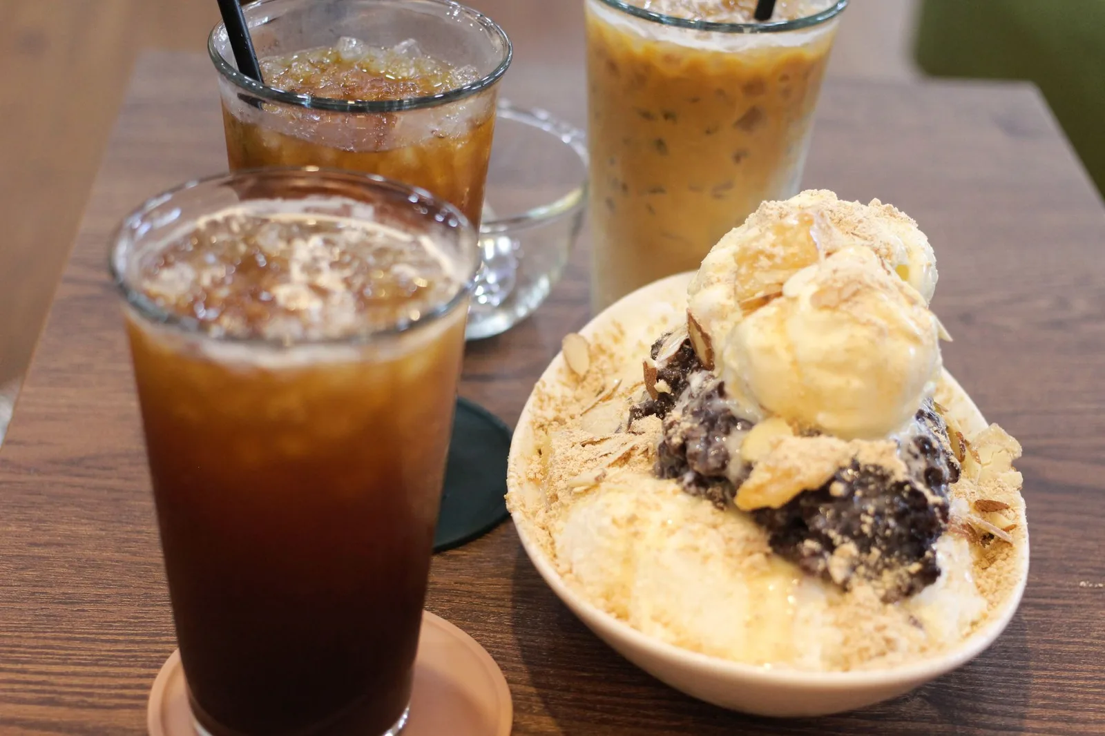 Enjoy iced coffee and Korean bingsu dessert with ice cream in a cozy cafe setting.