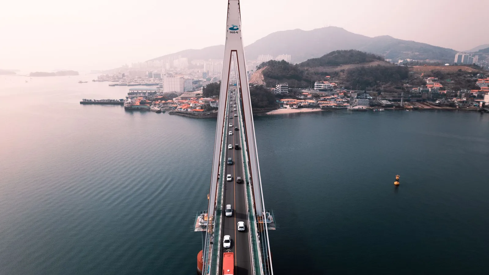 Stunning aerial view of a bridge connected to the city of Yeosu, South Korea over tranquil waters.
