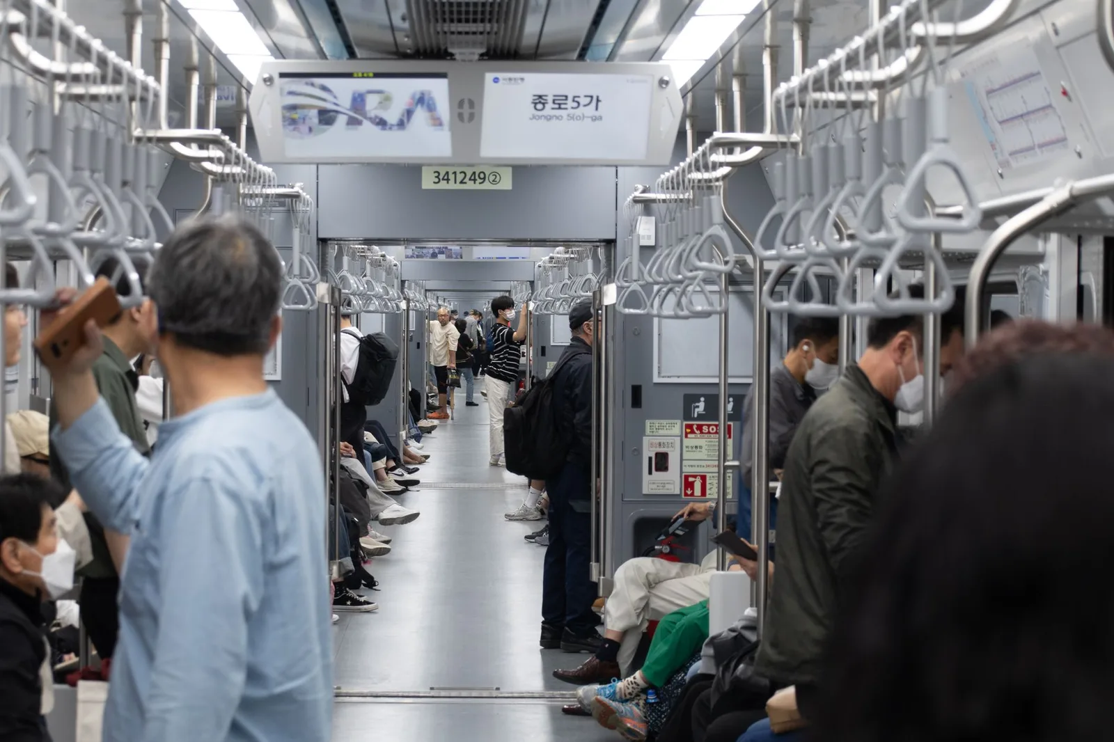A busy subway scene in Seoul with diverse commuters. Interior view showing daily urban life.