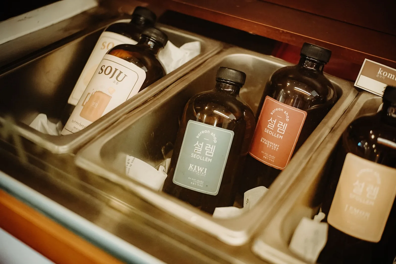 A selection of Korean soju bottles in an ice tray with flavors like kiwi, lemon, and more.