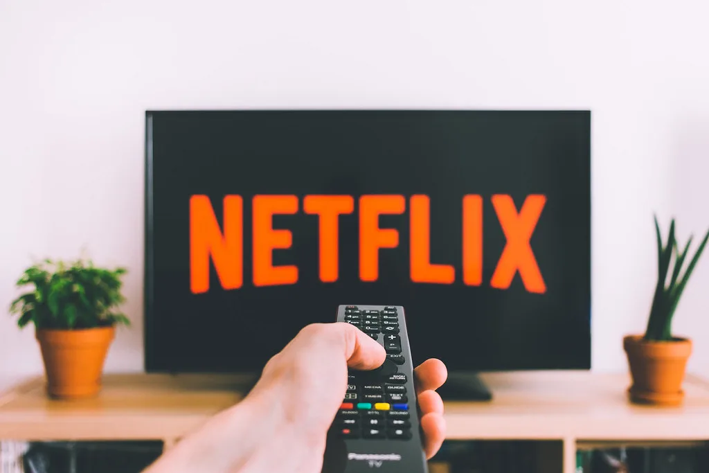 Pointing a remote at a TV showing the Netflix logo