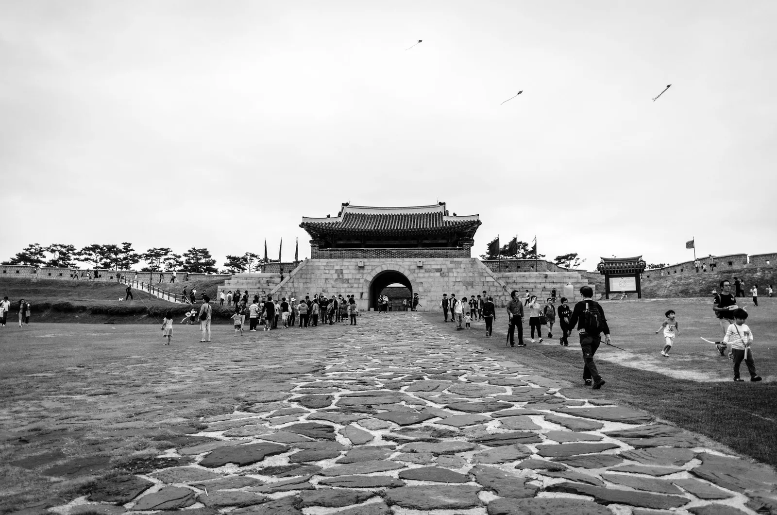 Monochrome image of Changryongmun Gate at Hwaseong Fortress, a historical landmark in Suwon, South Korea.