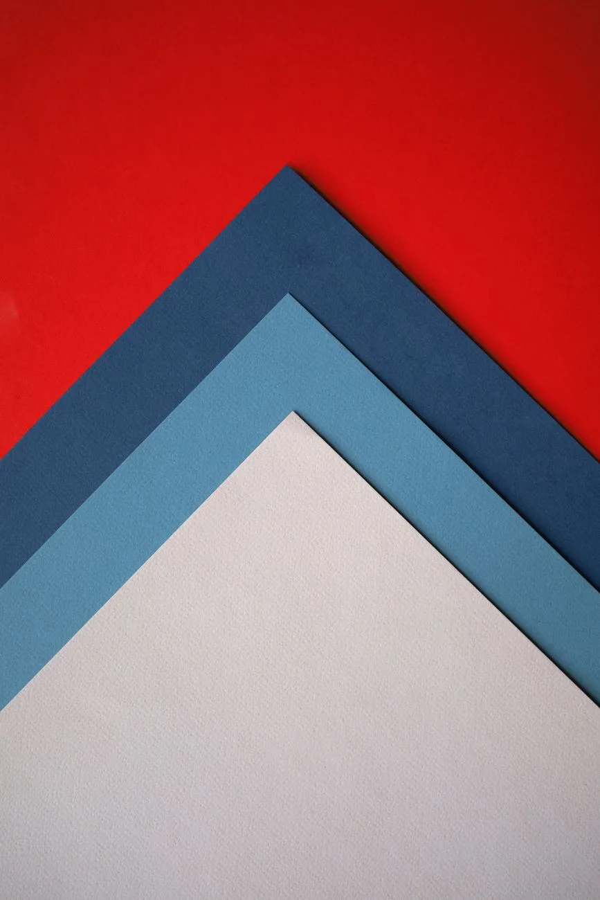 Abstract composition of layered red, blue, and white paper sheets.