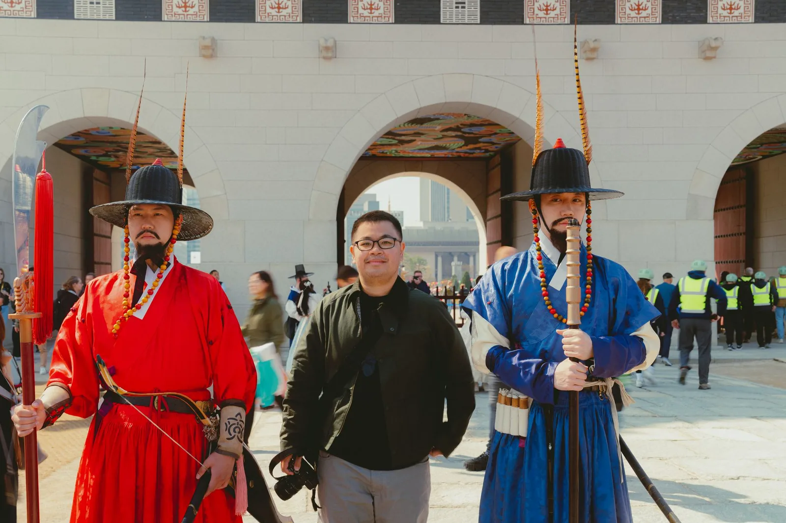 A visitor poses with traditional guards in front of Gwanghwamun Gate, Seoul.