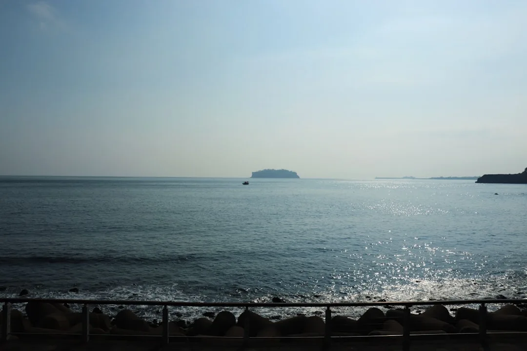 A body of water with a small island in the distance, illustrating the ferry option to Jeju.