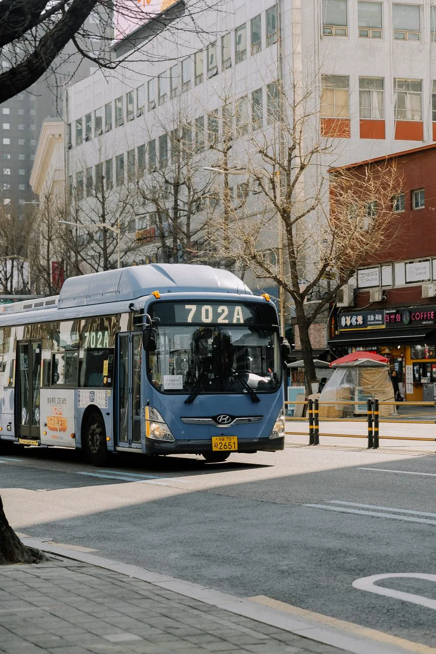 City bus with Hyundai logo on a bustling Seoul street, capturing urban life.